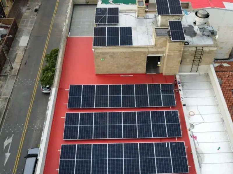 Vista aérea de la terraza del edificio Box Office, en Bogotá, con tres filas de paneles solares y más paneles sobre la cubierta de arriba