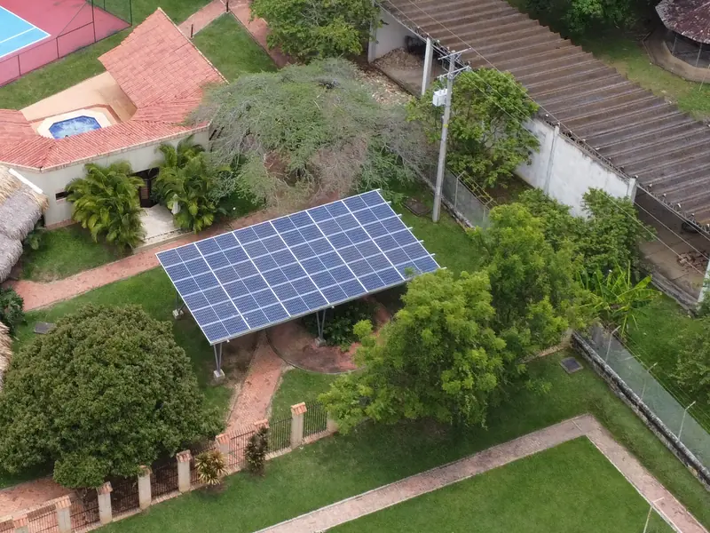 Pérgola de paneles solares en las zonas comunes de Madremonte, en Anapoima, rodeada de jardines y palmas