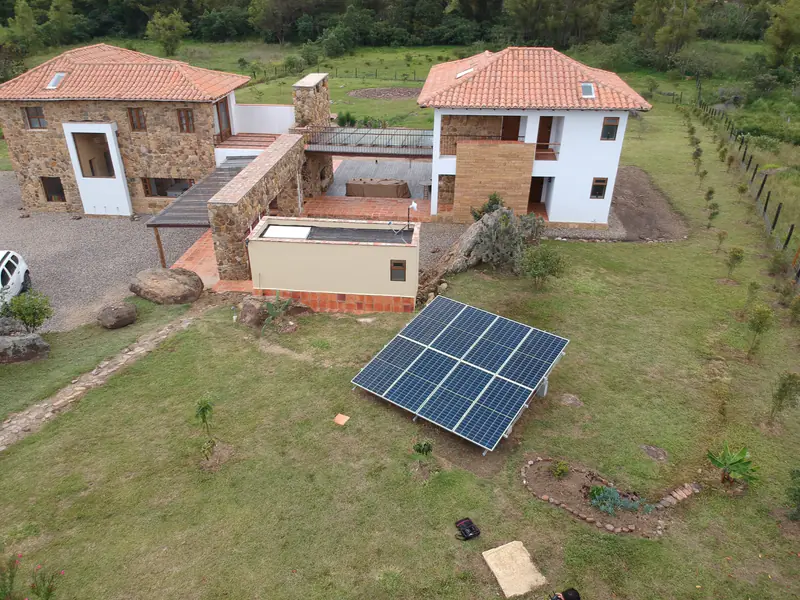 Paneles solares montados en el suelo, en el jardín de una casa de piedra en Villa de Leyva, Boyacá